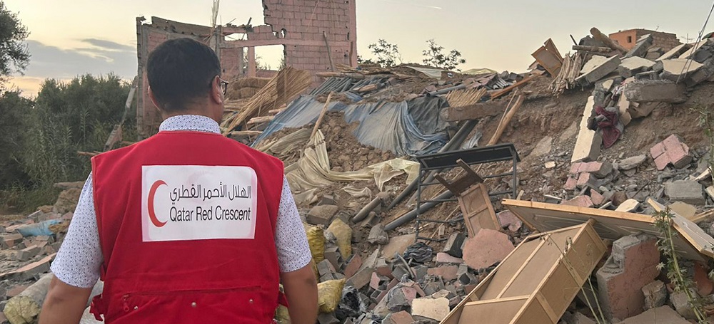 Red Cross Red Crescent volunteer surveys damage in Morocco.
